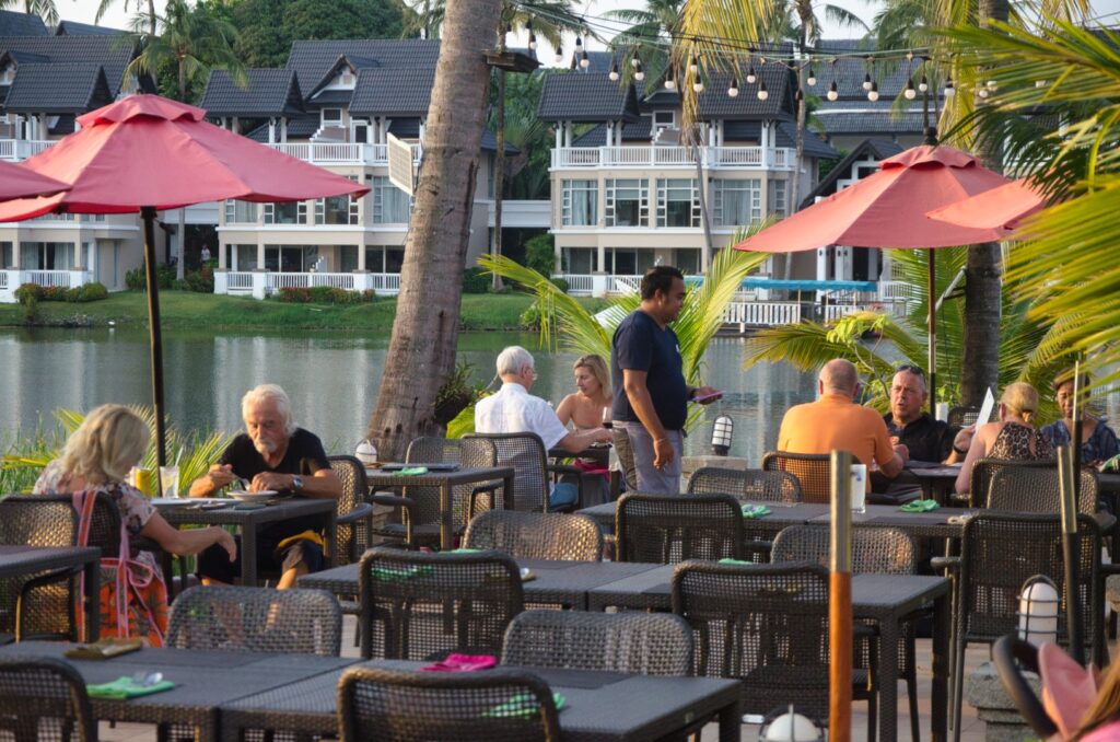 Terrasse aux parasols rouges avec vue sur le lac au Albatross Café, Laguna Phuket