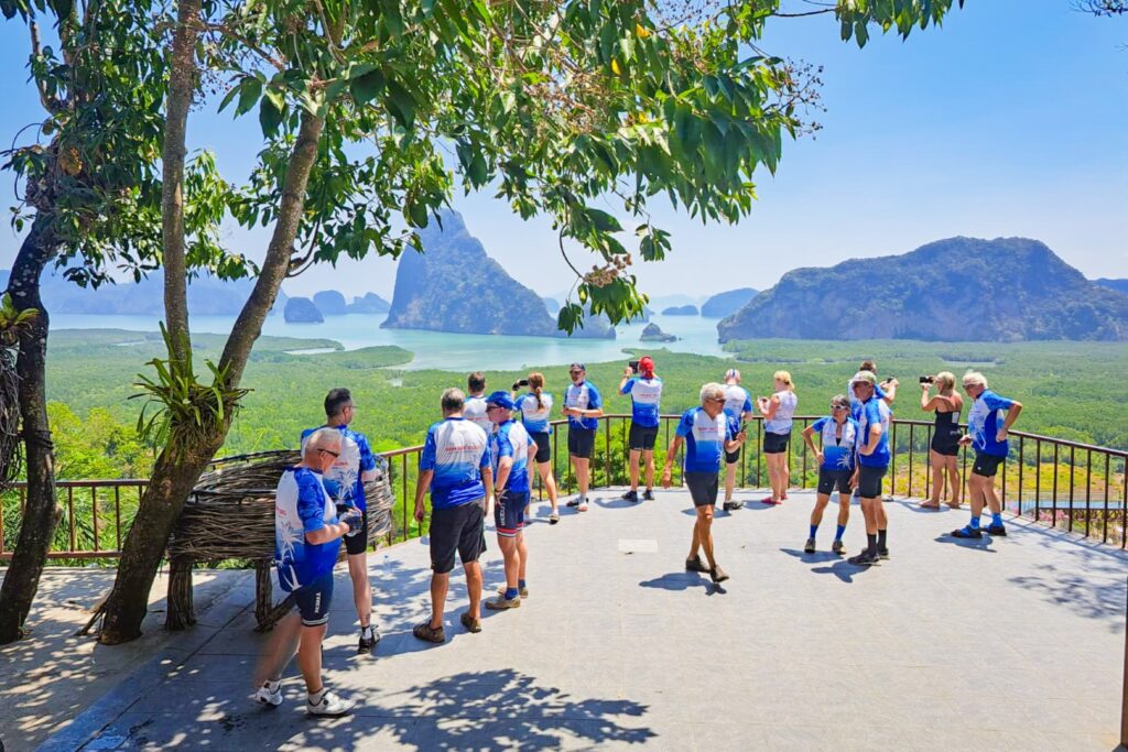 Cyclistes en maillot bleu à un point de vue sur la baie de Phang Nga