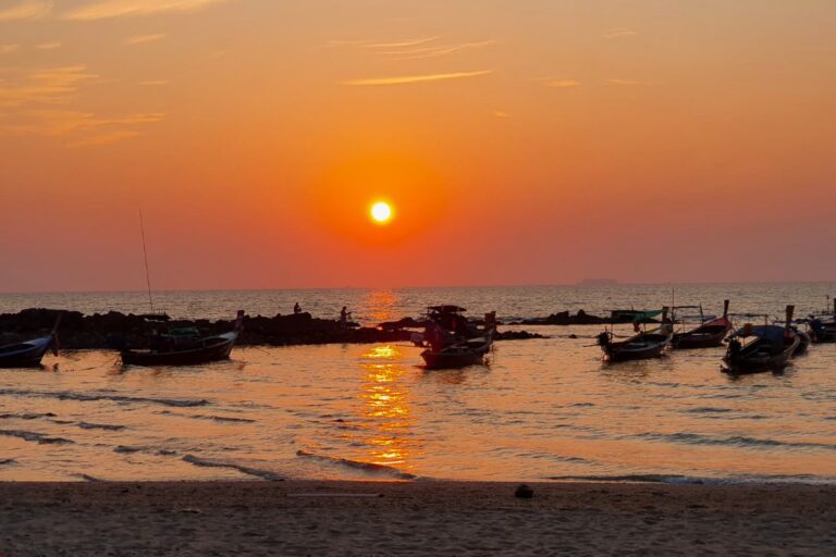 Sunset over fishing boats on a Thailand beach, a Siam Bike Tours rest stop