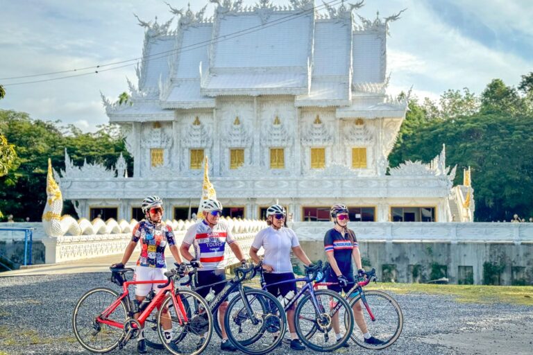 Cyclists pose at the White Temple (Wat Rong Khun) on a Siam Bike Tours multi-day cycling trip