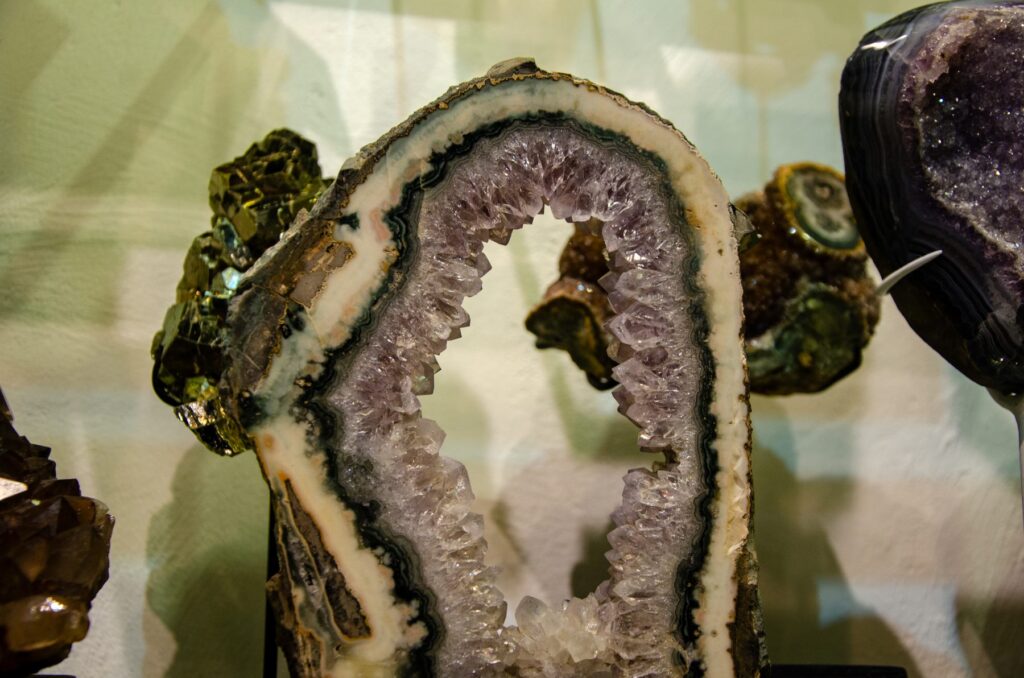 Cut edge of an amethyst geode showing a ring of pale crystals inside a white and dark banded rim