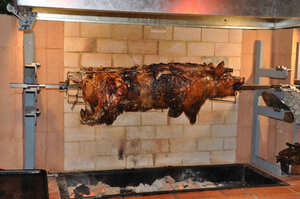 Whole pig roasting on a spit at Le Celtique, Rawai Phuket