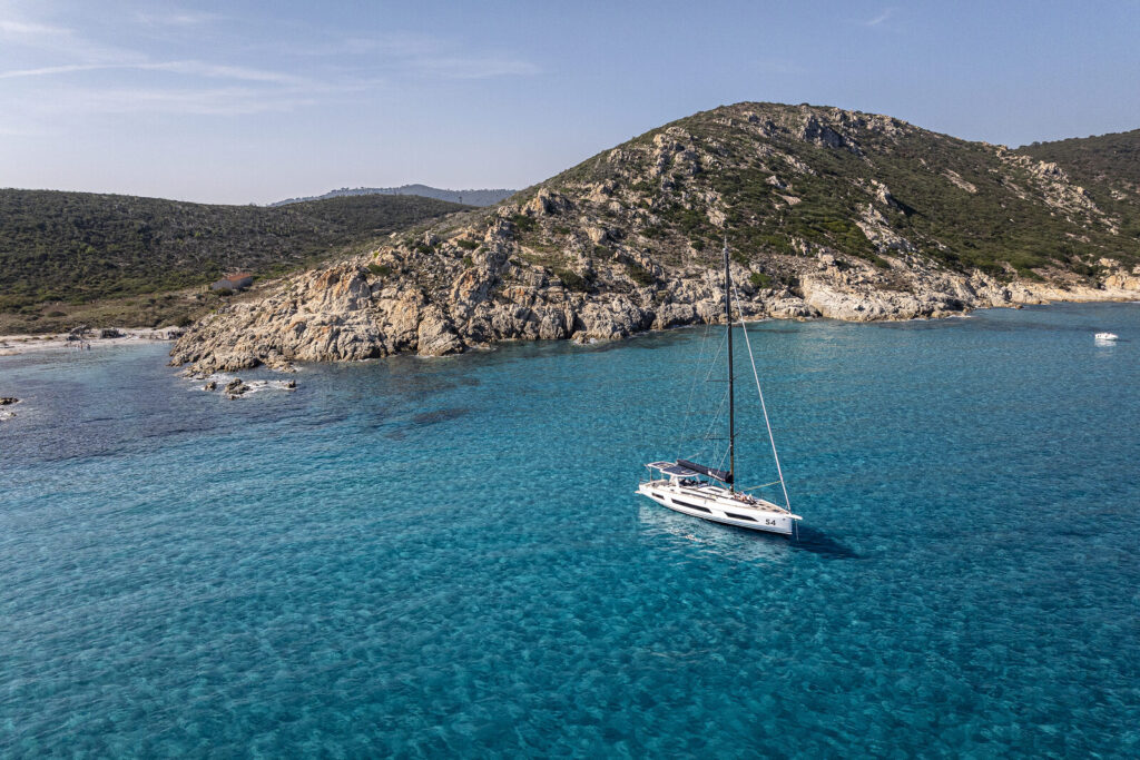 Sailing yacht at anchor off a rocky island