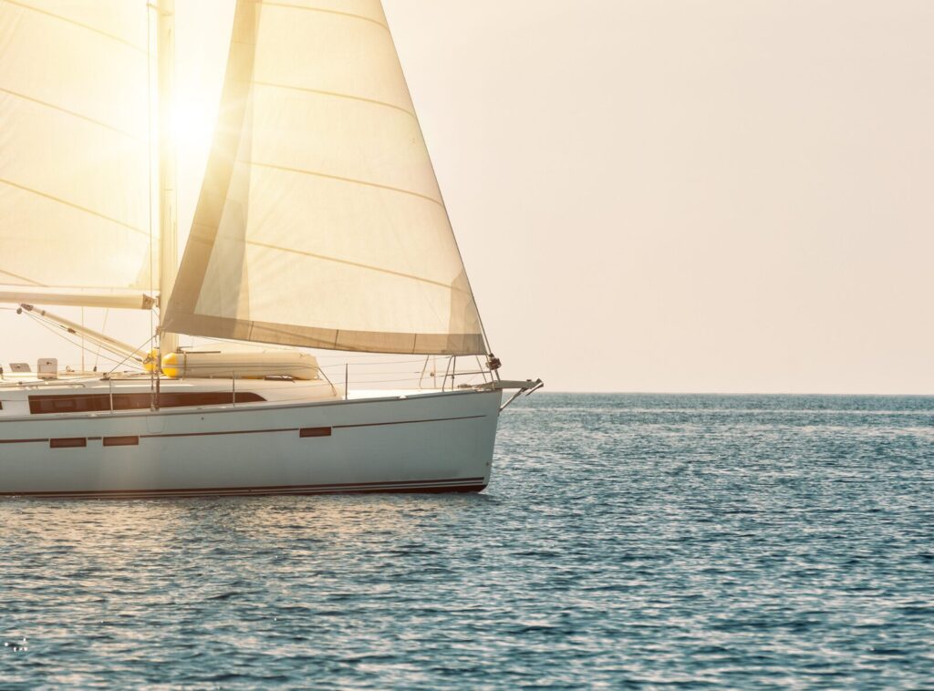 Sailing yacht with its sails set in warm evening light