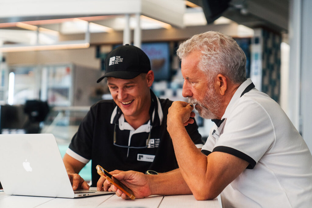 Two Yacht Sales Co. brokers looking at a laptop together