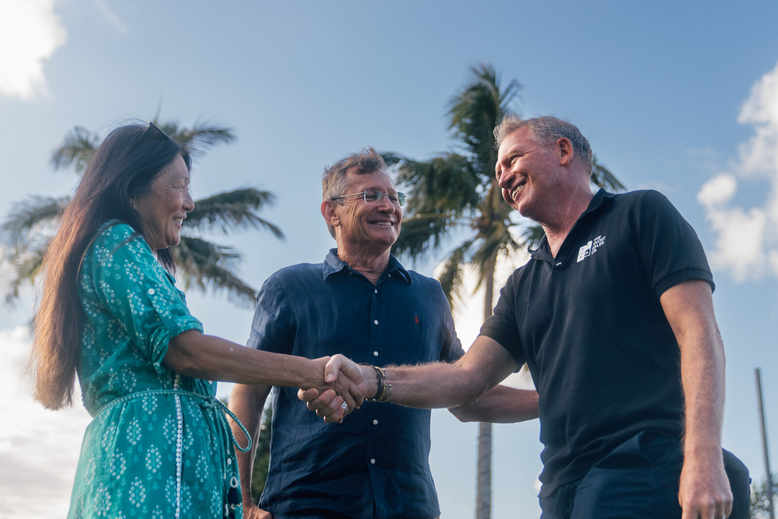 A Yacht Sales Co. broker shaking hands with a visitor at an event